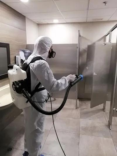 Técnico Chase aplicando desinfección en baños comerciales